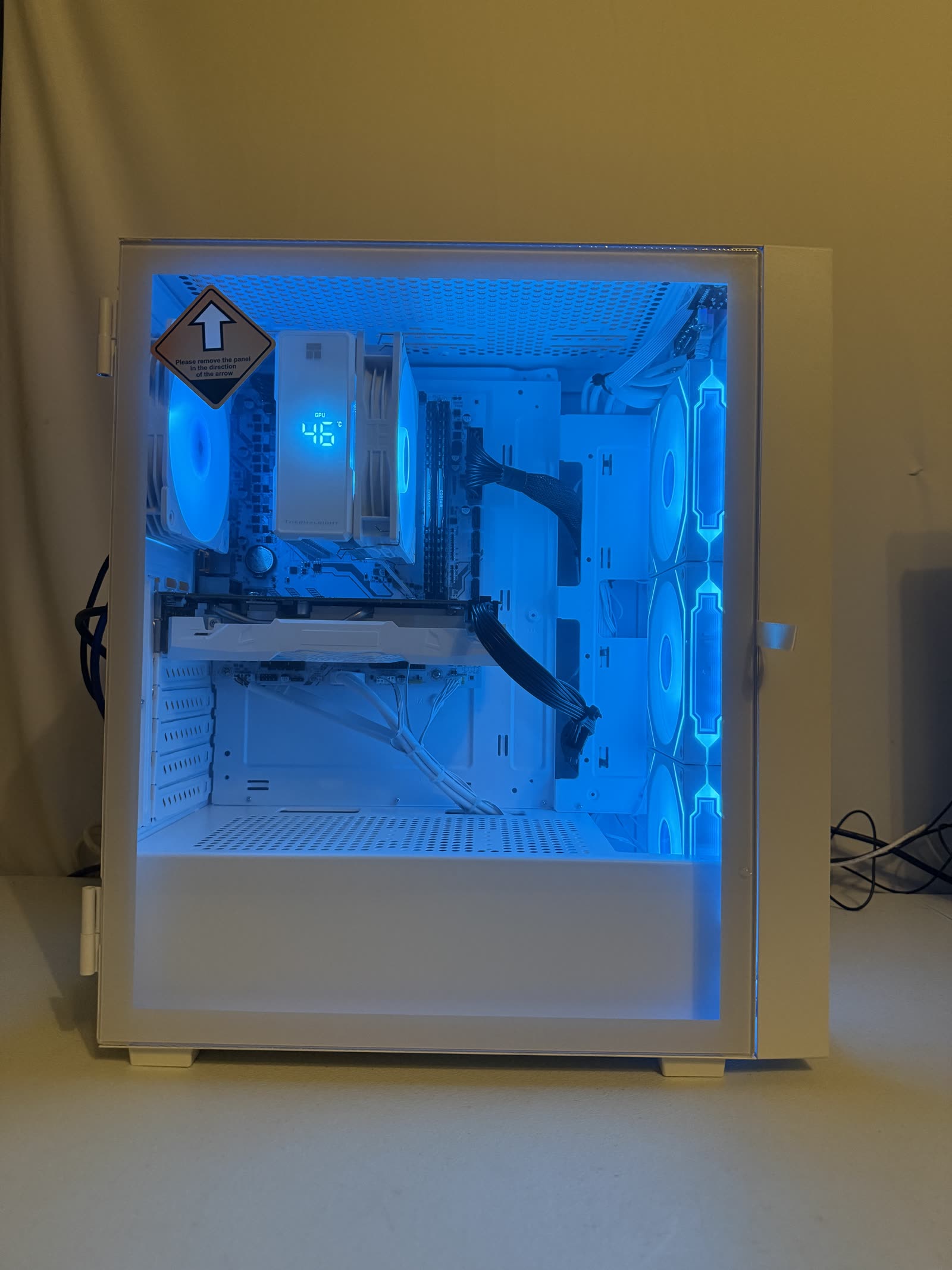 White custom PC with cyan and blue RGB lighting — front view with the side panel open and components visible