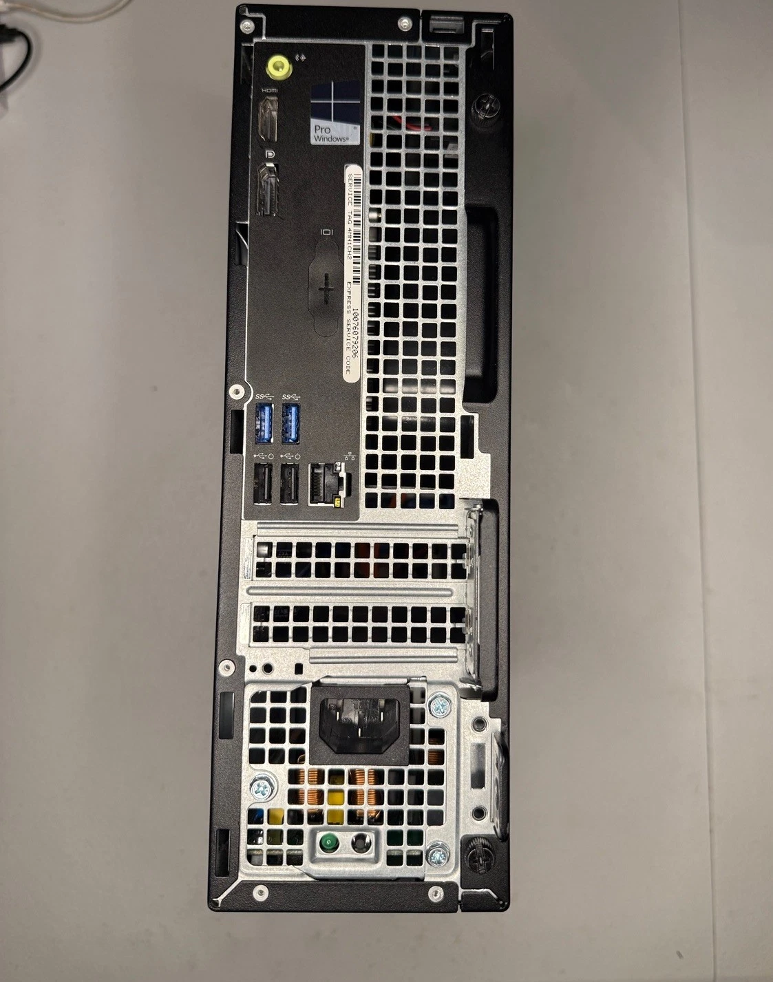 Rear of the Dell OptiPlex 3046 showing ports, a Windows Pro sticker, and internal components through the vents